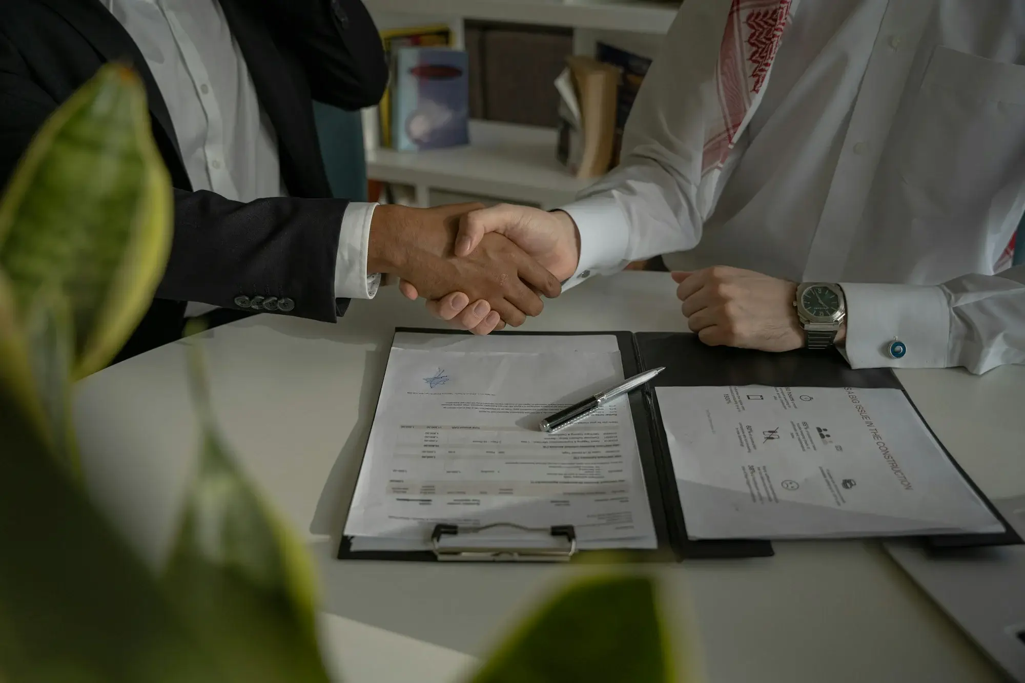Apretón de manos sobre un contrato firmado